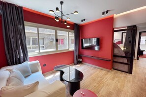 Appartement de base (Scarlet Condo) | Aire de séjour | Téléviseur connecté de 55 po avec télévision par satellite