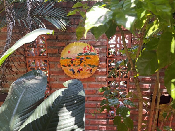 Un mur de briques orné d’une peinture circulaire décorative et d’une fenêtre à croisillons.