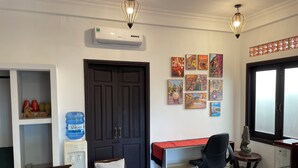 A modern office space with a desk, office chairs, a water dispenser, and artwork on the walls. - Blue Beach Village (Da Nang)