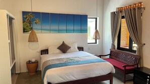 A bedroom with a bed, a window with curtains, a wall-mounted painting, a bedside table, and a chair. - Blue Beach Village (Da Nang)