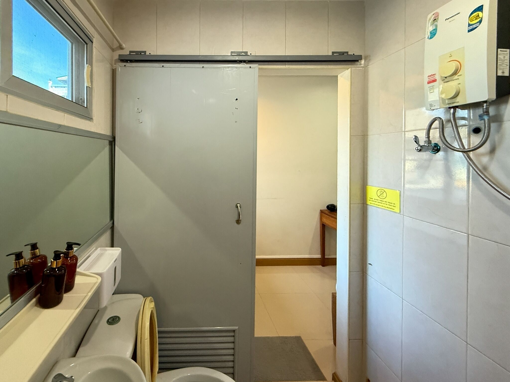Un baño con inodoro, lavamanos y zona de ducha.