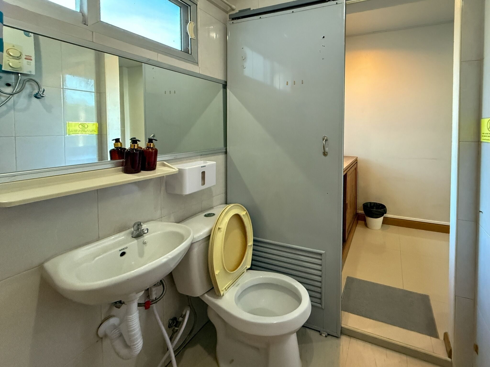Ein kleines Badezimmer mit Waschbecken, Toilette und Spiegel.