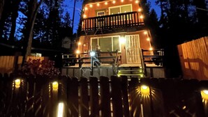 A two-story wooden cabin with a balcony, surrounded by trees. - Moonridge Manor Cozy Retreat with Hottub (Big Bear Lake)