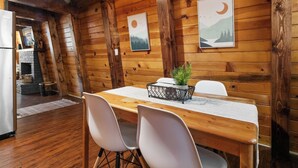 A wooden interior with a dining table, chairs, and artwork on the walls. - Moonridge Manor Cozy Retreat with Hottub (Big Bear Lake)