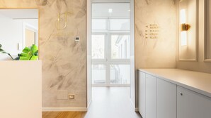A modern hotel room with a marble wall, a large window, and a minimalist design.