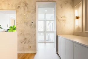 A modern hotel room with a marble wall, a large window, and a minimalist design. - La Merope Guest House de Charme (Verona)
