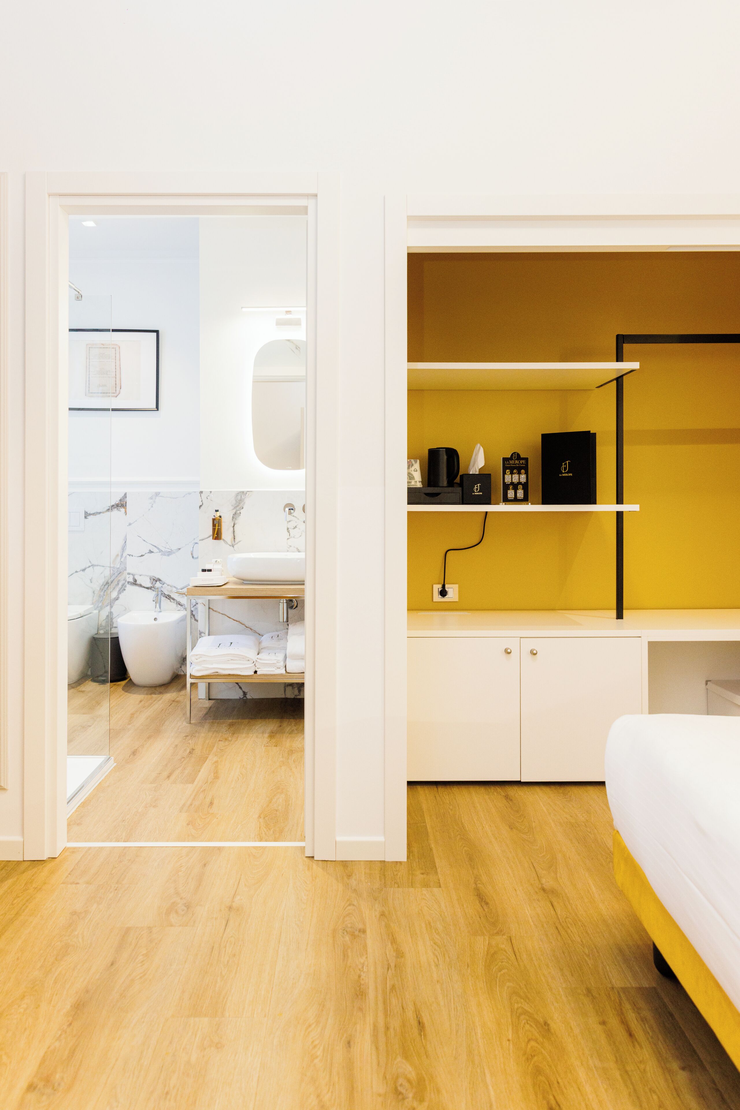 A modern bathroom with a marble sink, a white toilet, and a shower area.