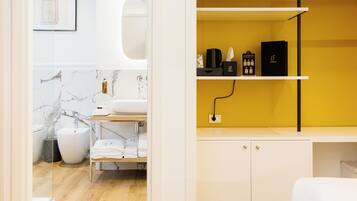 A modern bathroom with a marble sink, a white toilet, and a shower area.