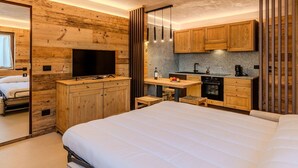 Une chambre compacte avec un grand lit, une télévision et une petite kitchenette.