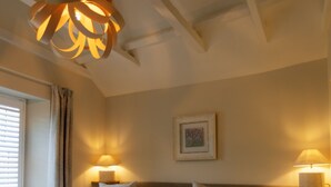 Habitación de hotel con dos camas, una lámpara de araña grande y dos lámparas de noche.