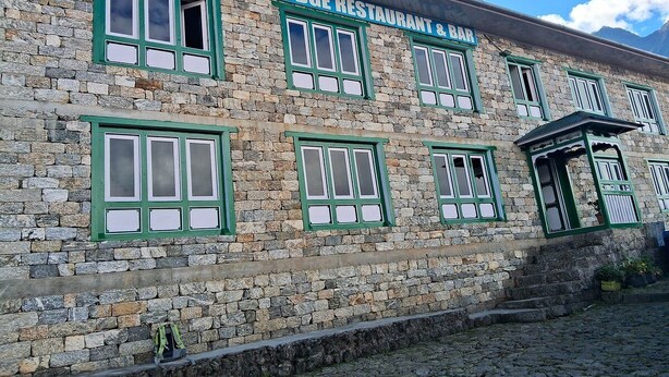 Un bâtiment en pierre doté de nombreuses fenêtres et d’une enseigne indiquant : « Restaurant et bar Mountain View Lodge ».