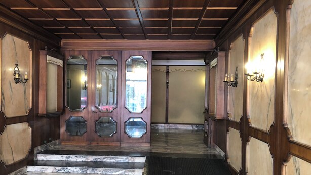 A grand entrance with a marble floor, ornate wooden doors, and wall sconces. - Cozy apartment 5 minutes from the metro, ideal for visiting Rome (Roma)