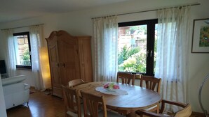 A dining area with a round wooden table, six wooden chairs, and a cabinet. - FERIENHAUS GERDA - Vacation in the sunniest region of Germany (Friesenheim)