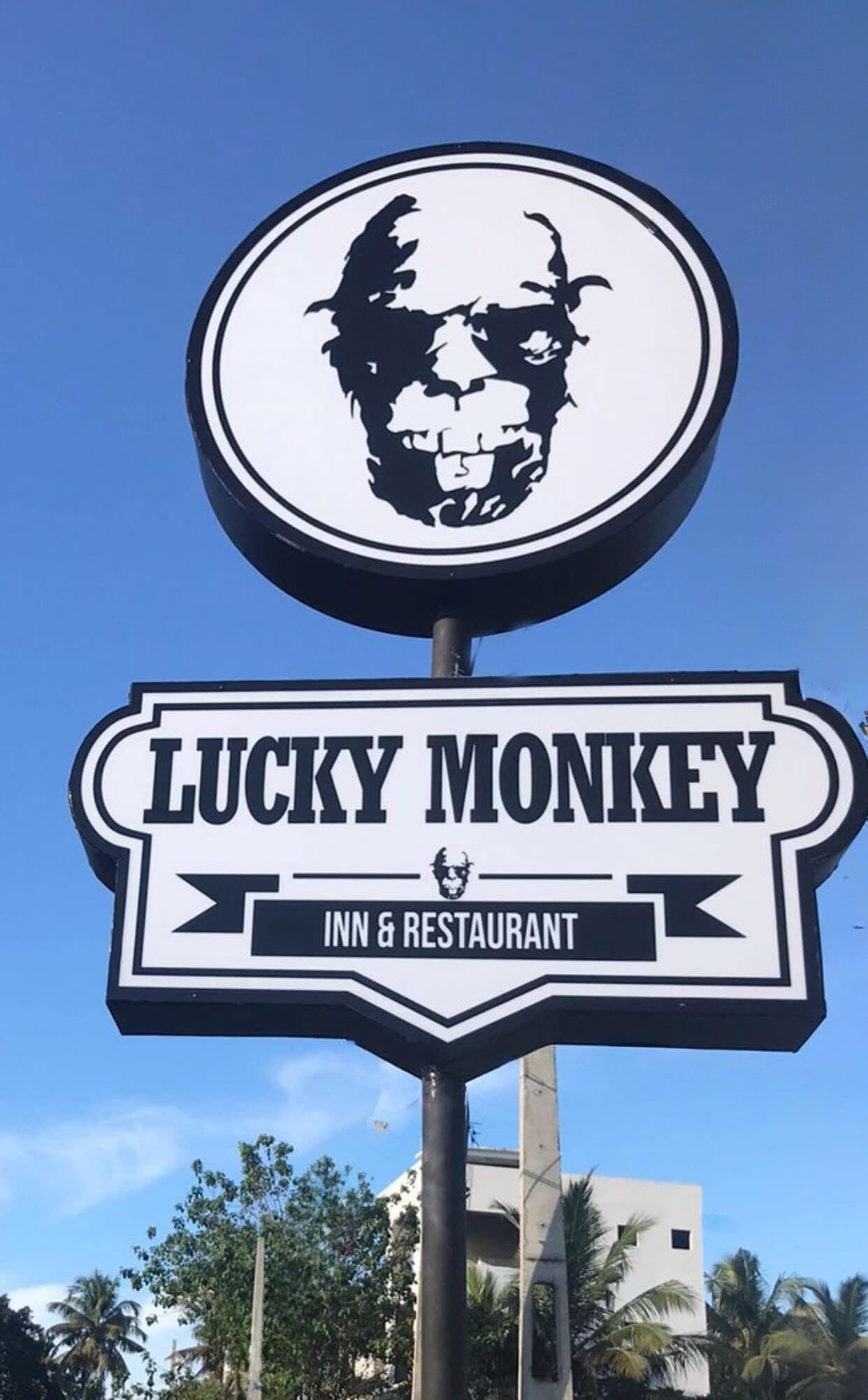 A sign for Lucky Monkey Inn & Restaurant with a circular logo above the name.