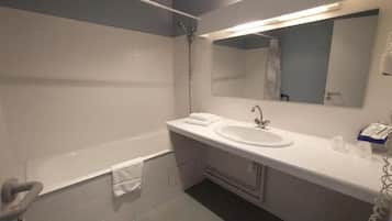 Een bad/douchecombinatie, een haardroger, handdoeken, zeep