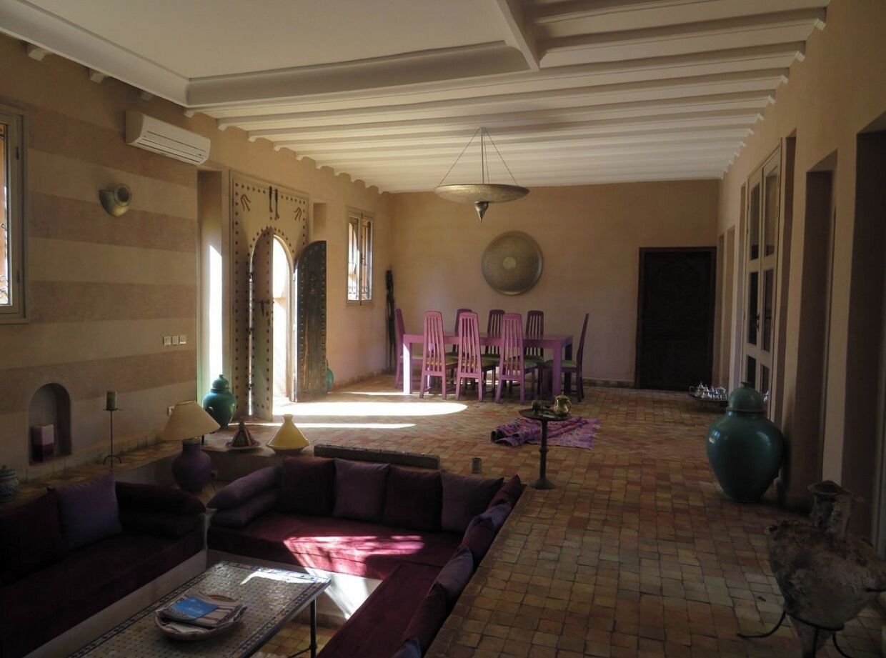 A spacious living room with a sofa, chairs, and a dining area with a table and chairs.
