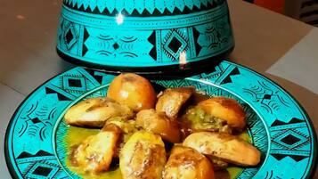 A plate of chicken pieces with a decorative blue and black patterned plate and a matching blue pot.
