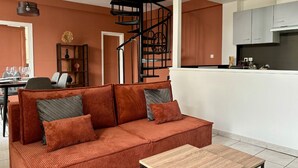 Un salon moderne avec un canapé, une table basse et un escalier en colimaçon.