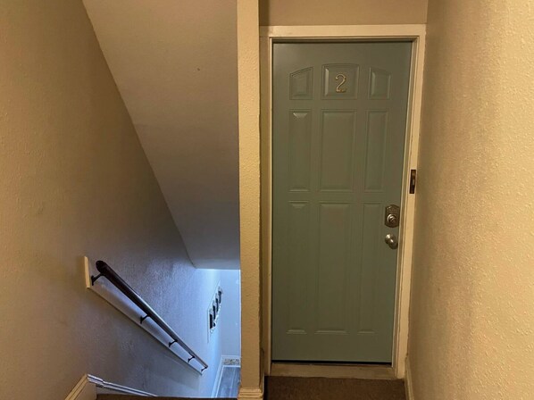 Una puerta azul turquesa cerrada, con un picaporte de latón y una pequeña placa de latón encima.