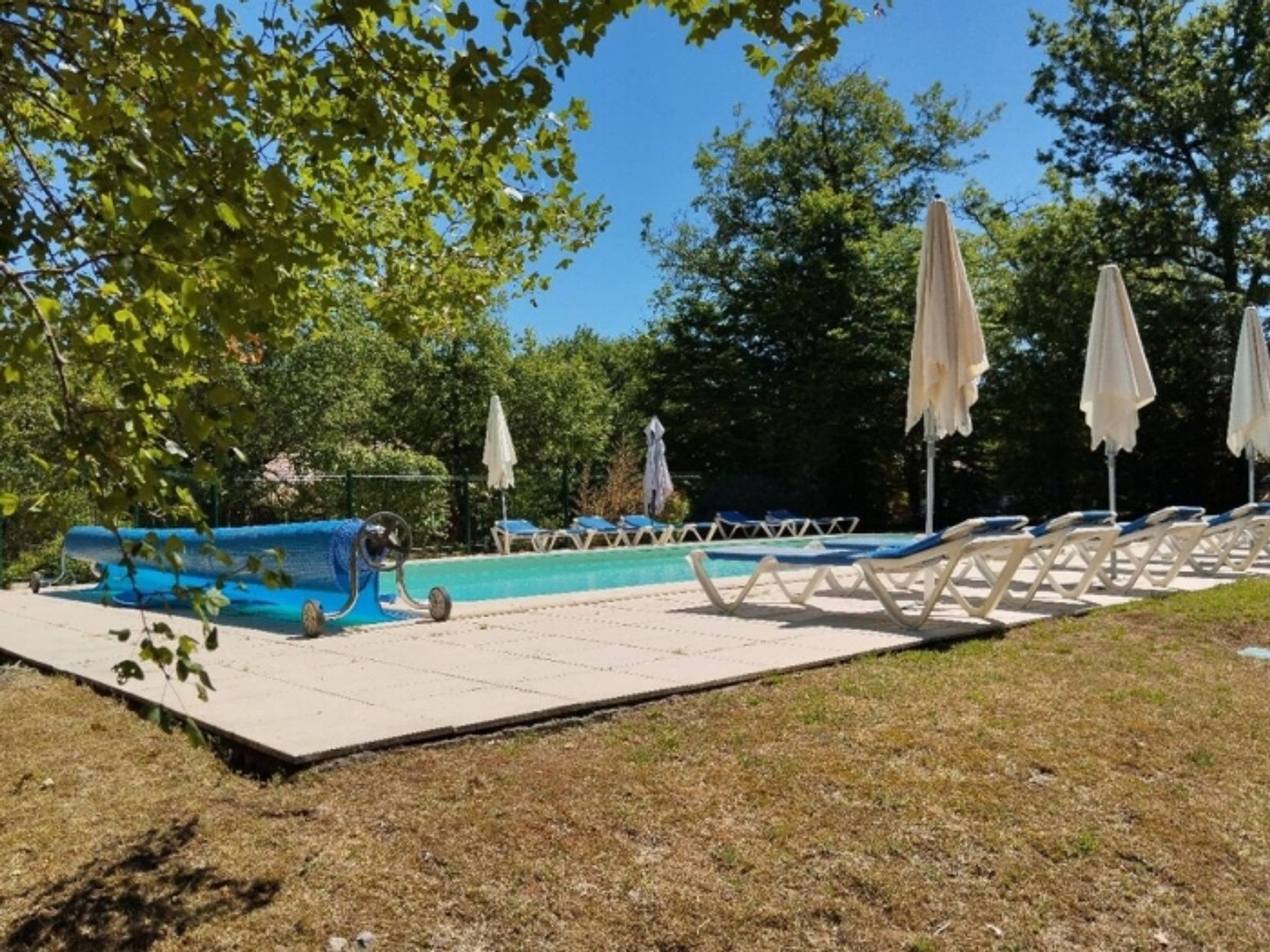 Area piscina con lettini e ombrelloni.