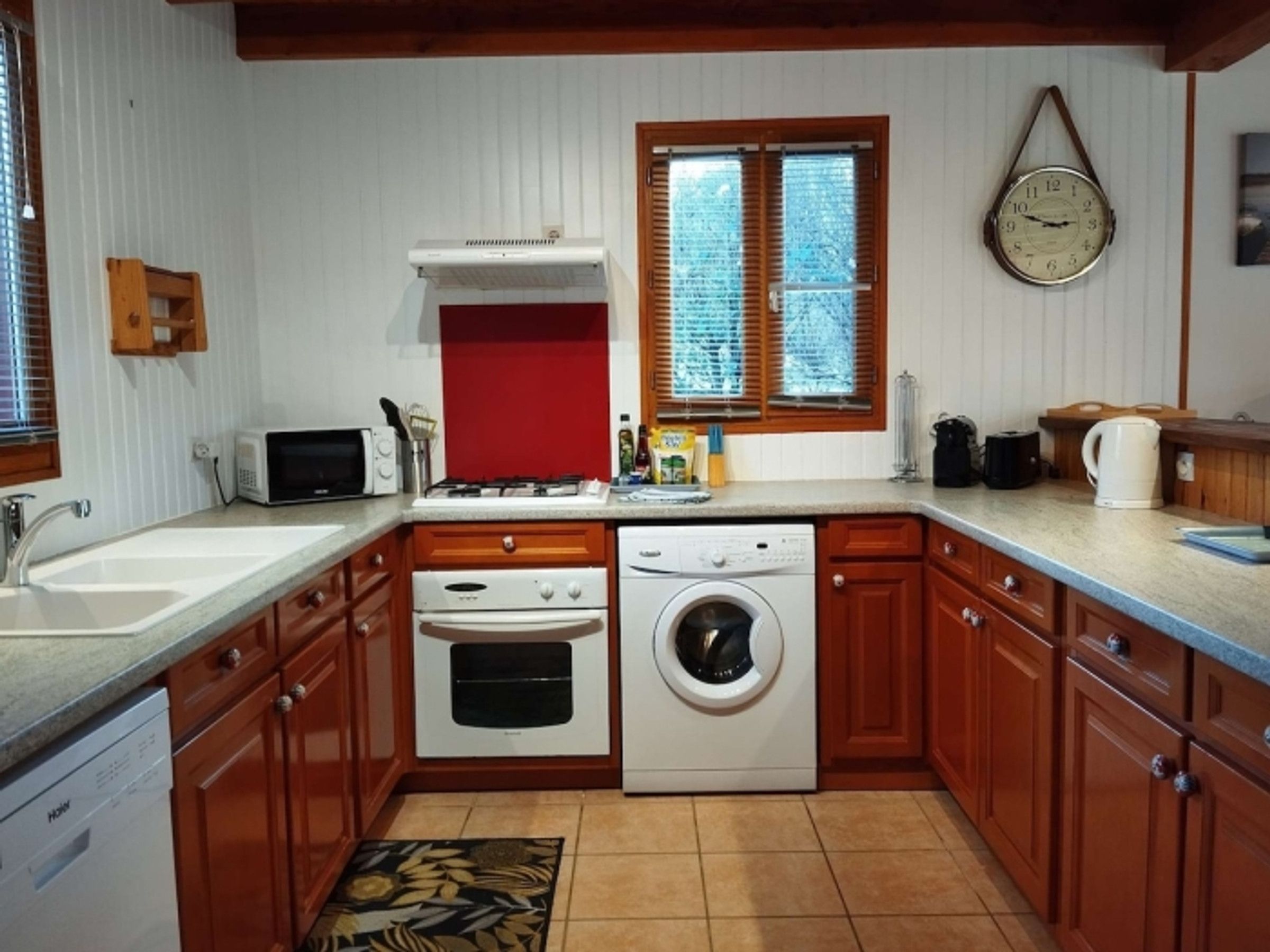 Een praktische keuken met een magnetron, fornuis, oven en vaatwasser.