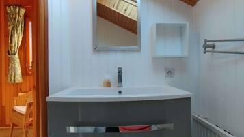 A bathroom with a white sink, a mirror, and a towel rack.