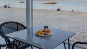 A table with a meal and a view of the beach and sea. - ALAHLAM CHALET YANBU (Yanbu)