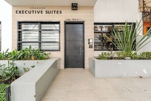 A building entrance with a sign reading "GRANADA EXECUTIVE SUITES" and a door labeled "Calle 18N # 7".