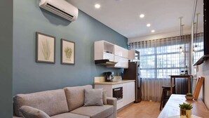 A modern living room with a sofa, a small kitchen area, and a dining table. - G102 - Stylish 1-Bed in Granada | Fast WiFi Included (Cali)