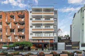 Stunning urban building with a unique brick and panel facade, featuring a storefront and balconies.