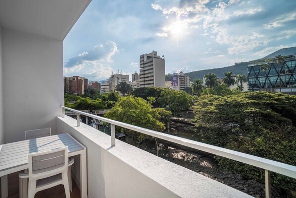 Enjoy the city view from this balcony with a table and chairs.