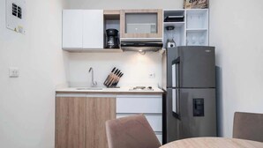 A compact kitchen with a refrigerator, coffee maker, and a microwave. - M202 - Río Bulevar | Zona Rosa and Historic Center (Cali)
