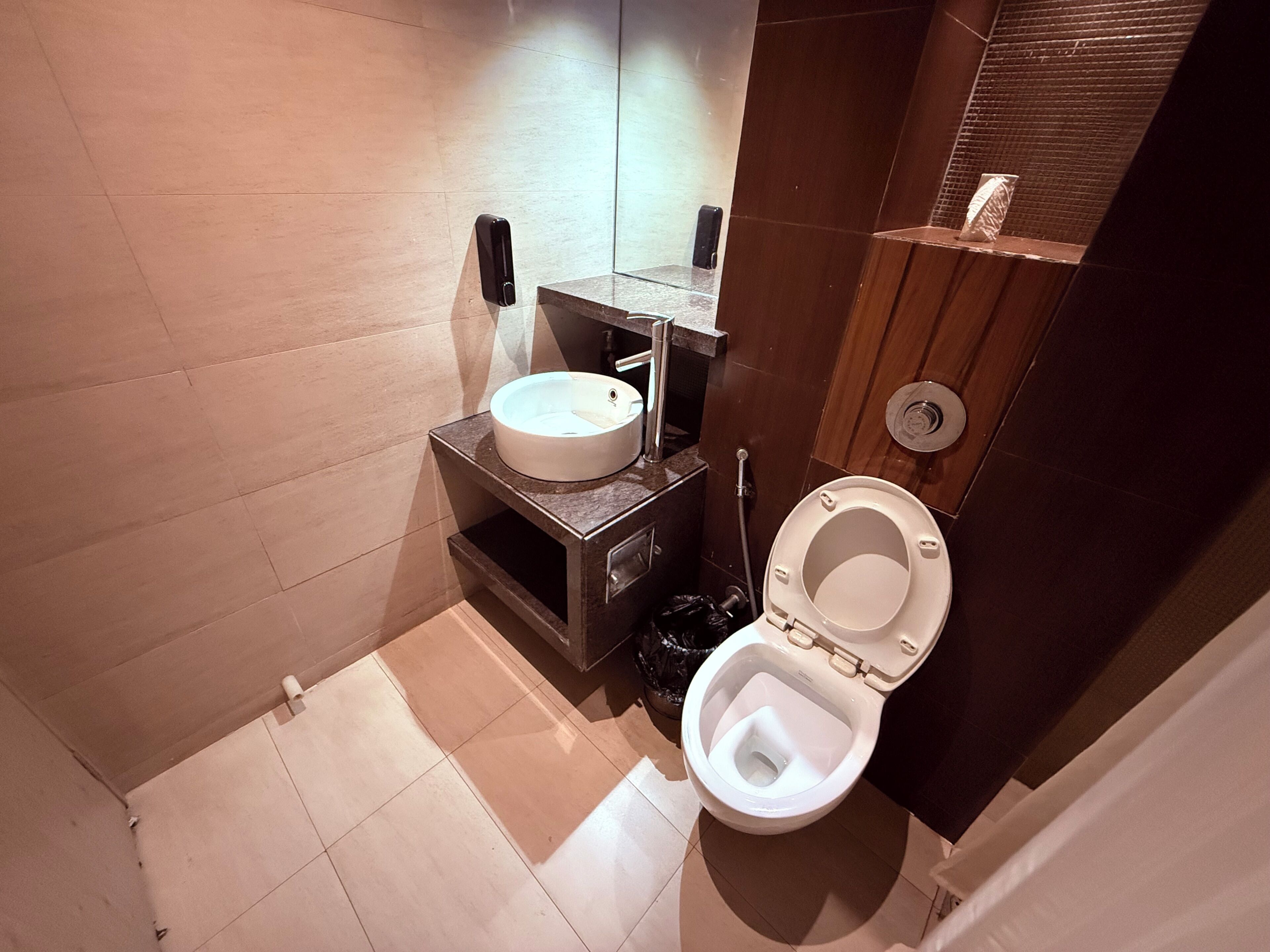 Une petite salle de bain avec un lavabo blanc, des toilettes et un miroir.