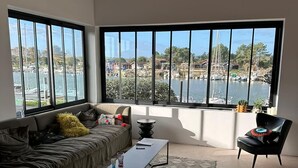 A modern living room with a large window overlooking a marina. - House on the harbour and near the salt marshes, beach 150 m away (La Teste De Buch)