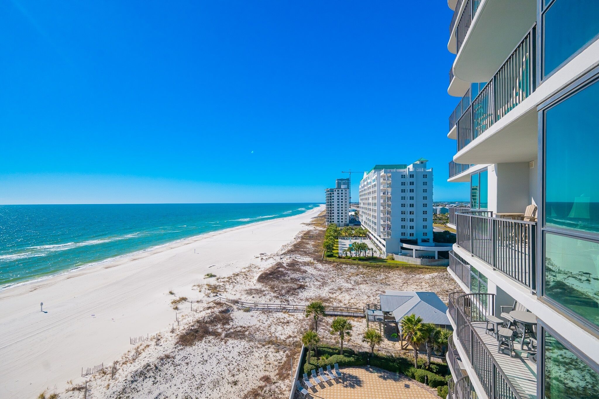 A beachfront hotel with a view of the ocean and beach.