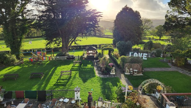 A garden with a play area, picnic tables, and a gazebo. - OYO Lavender House Hotel (Newton Abbot)