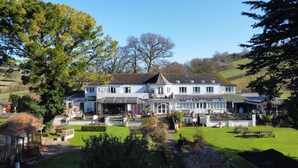 A large, two-story house with a well-maintained garden, multiple windows, and a visible outdoor seating area. - OYO Lavender House Hotel (Newton Abbot)
