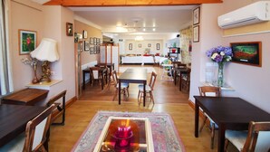 A dining area with wooden furniture, a central table, and a decorative glass centerpiece. - OYO Lavender House Hotel (Newton Abbot)