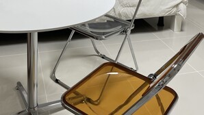 A hotel room with a white bed, a white round table, and a foldable chair with a transparent seat. - Cozy 1-bedroom apartment with AC, WiFi in lovely Seoul (Seoul)