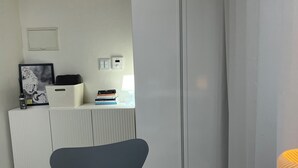 A room with a white table, a grey chair, a white wardrobe, and a radiator. - Cozy 1-bedroom apartment with AC, WiFi in lovely Seoul (Seoul)