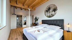 Une chambre à coucher comprenant un lit, une table de chevet et une œuvre d’art accrochée au mur.