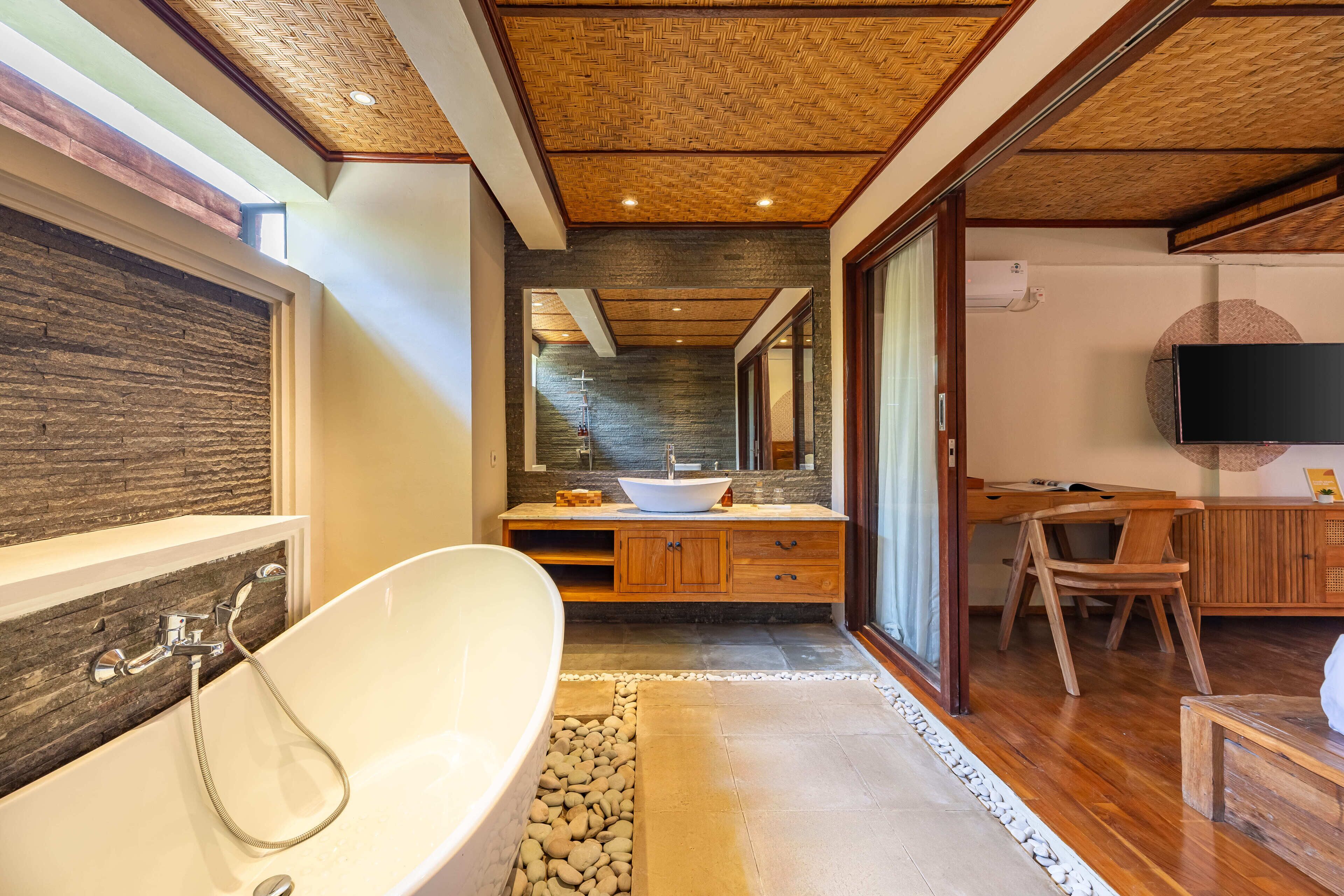 A modern bathroom with a freestanding bathtub, a wooden vanity, and a large mirror.