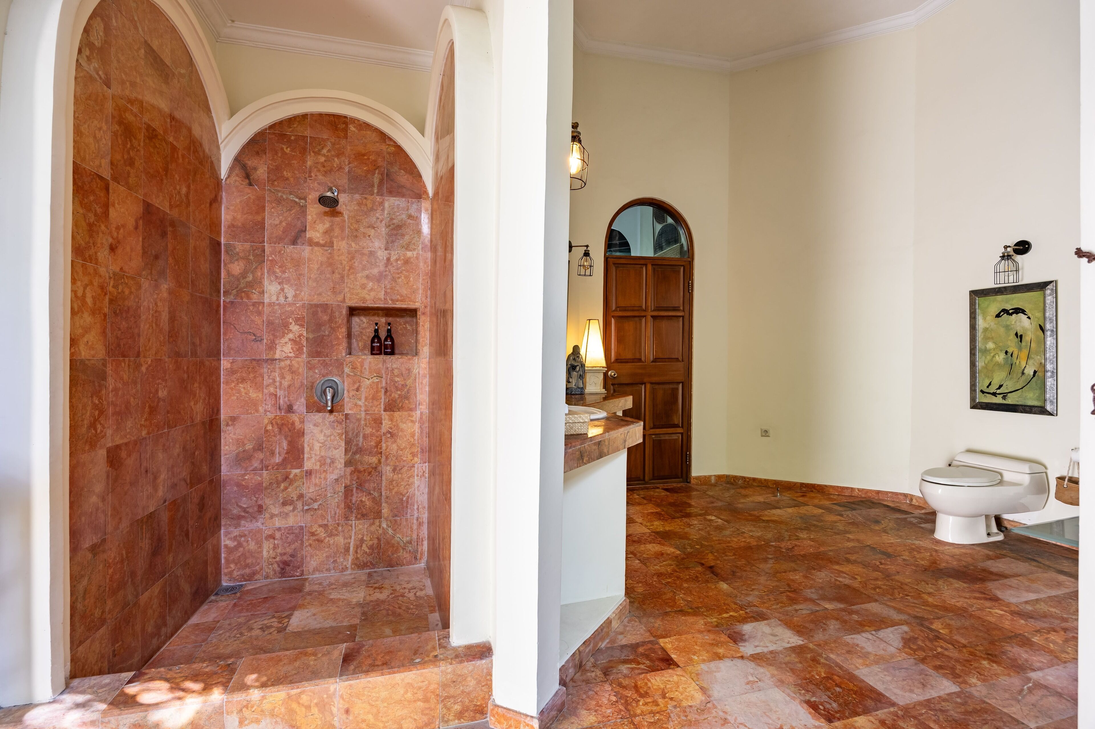 A bathroom with a shower, toilet, and sink.