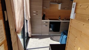 Une cuisine de taille réduite, avec des meubles de rangement en bois, un évier et une cuisinière.