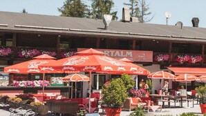 A restaurant with outdoor seating, red umbrellas, and mountain views. - Apartment in Seefeld Near Ski Slopes (Seefeld in Tirol)