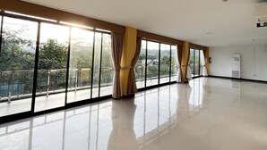 A spacious room with large windows, a polished floor, and a ceiling with recessed lighting. - Sacaan Tropical Breeze Resort (Sogod)