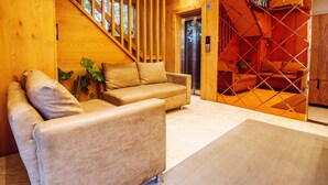 Un interior moderno con una escalera de madera, un sofá y una planta.