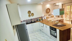 Una cocina moderna con una isla de madera, armarios blancos y un horno empotrado.