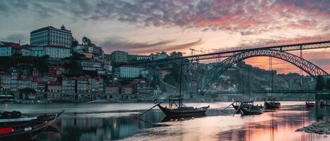 Un río con barcos, un puente y edificios al fondo.