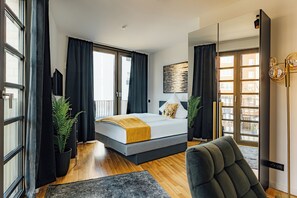 Un dormitorio moderno con cama, ventana grande y vistas a la ciudad.